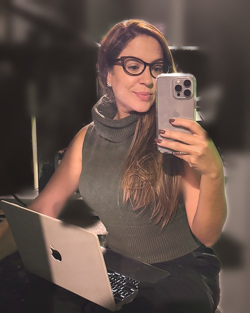 Maria Eduarda Vila Nova, a Duda, sentada com o notebook no colo dentro do estúdio de gravação